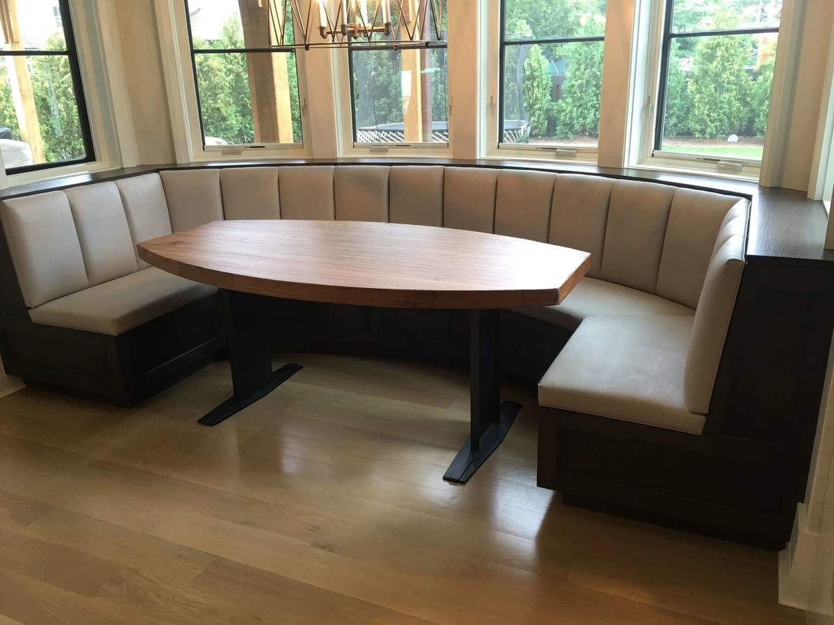 Upholstered breakfast nook beneath corner windows